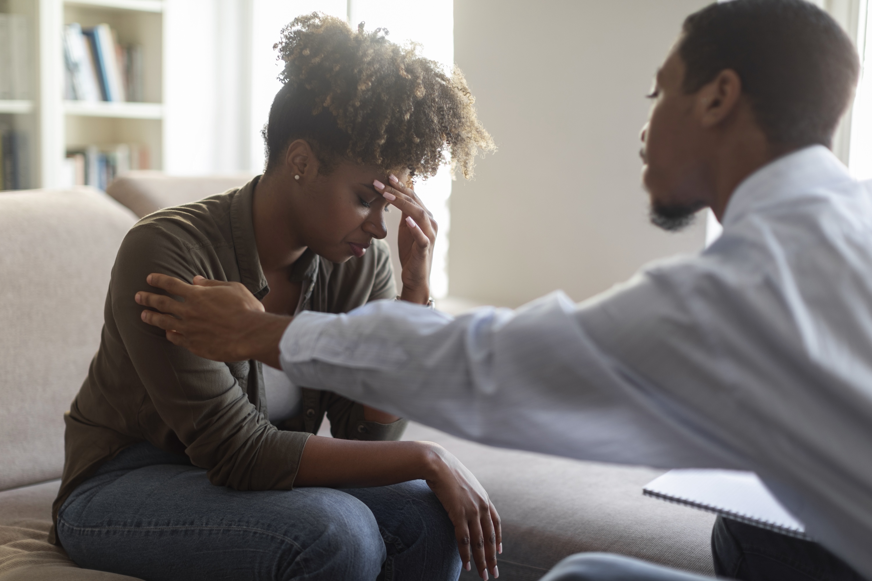 Black man psychologist comforting upset woman